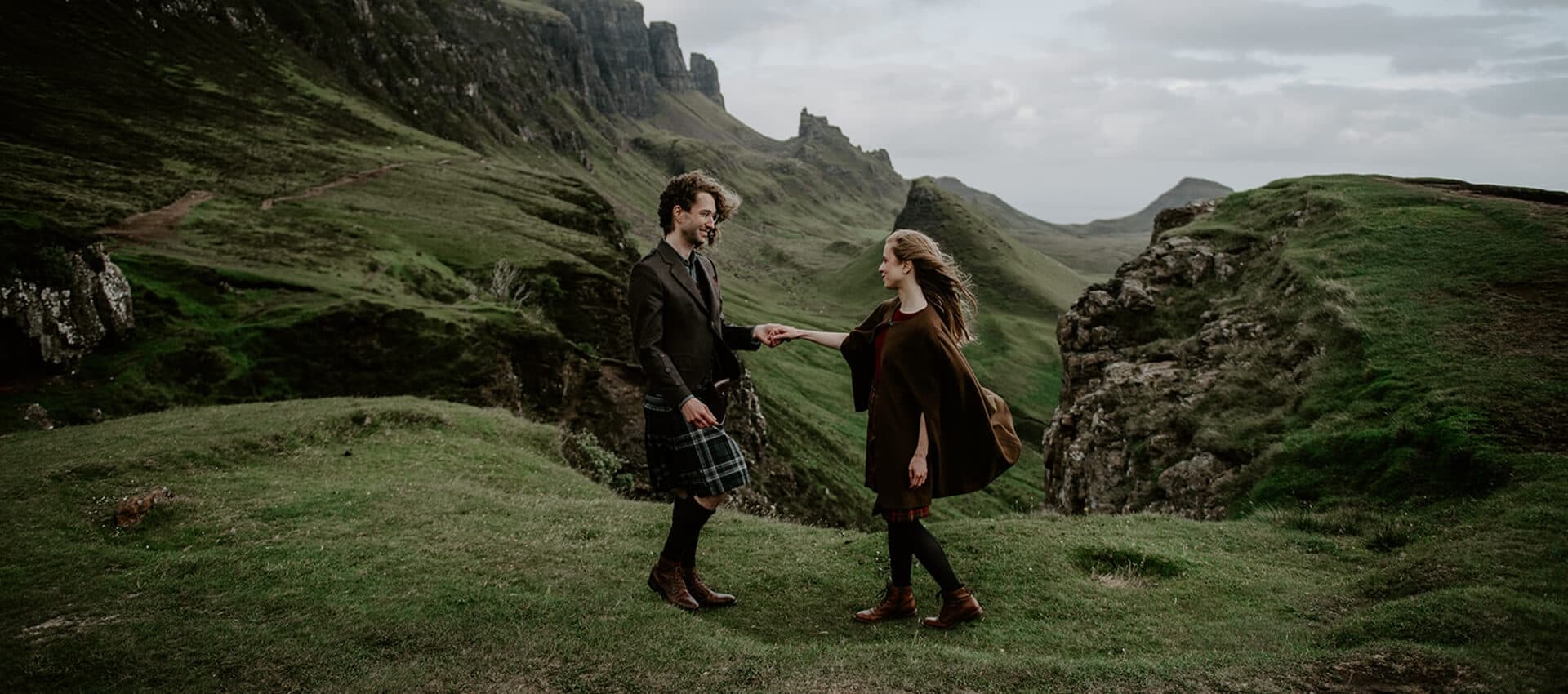 Wedding couple outdoors in beautiful landscape view of rugged rocks on the Isle of Skye